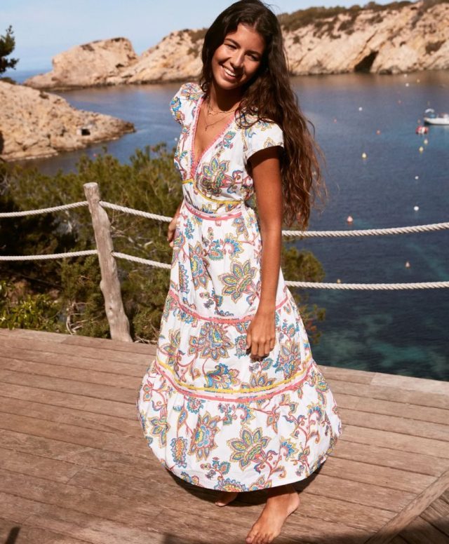 woman wearing dress on dock in front of sea
