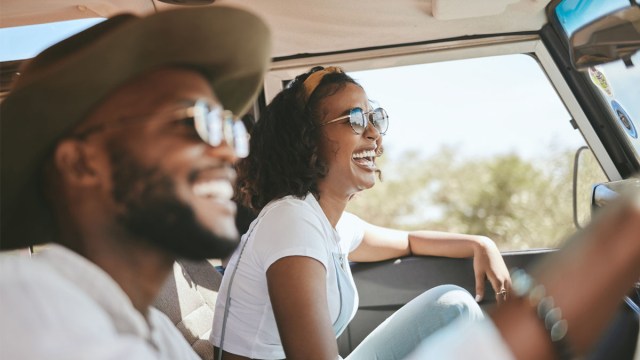 a happy couple smiling while driving in a car