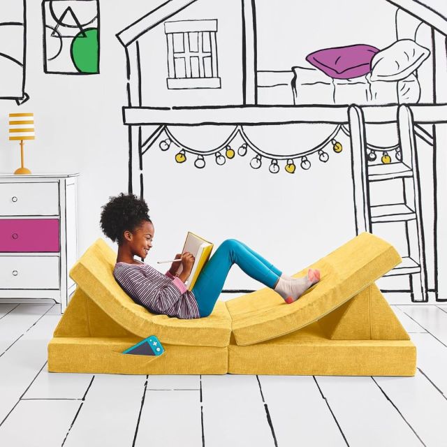 tween girl sitting on yellow modular play couch