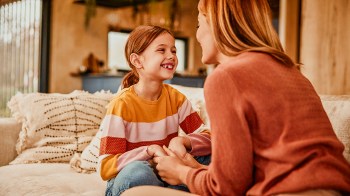 mother and daughter having a heartfelt conversation on the couch