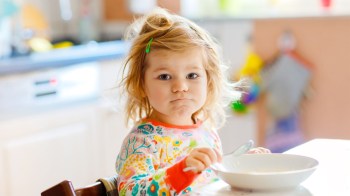 A little girl who isn't sure about the texture of her porridge, one of the 6 kinds of picky eaters