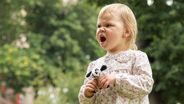 A toddler looking angry and saying no