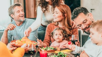 a young child sitting on their mom's lap at one o ftheir holiday meals