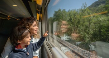 Kid riding Eurail train with family in Europe.