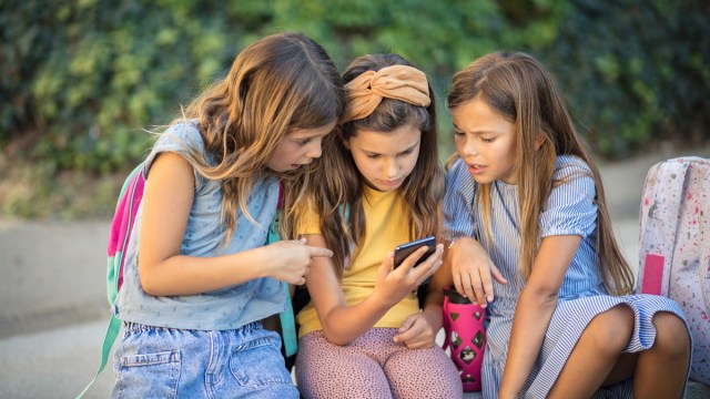 three tween girls looking at one of the best cell phones for kids