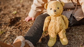 A little girl sitting with a teddy bear for a story on how to help families after the los angeles wildfires