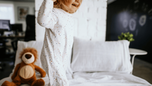 A hyper kid in pajamas jumping on the bed and in. need of some calming bedtime activities