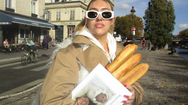 DJ MadBadTing walking in Paris holding three baguettes and a Tinybeans photo book