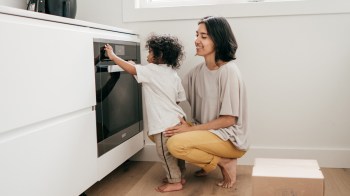 A mom hanging with her toddler in the kitchen because she's got extra time after using smart mom productivity hacks and family organization apps