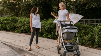 mom friends hanging out, one pregnant and the other with a stroller