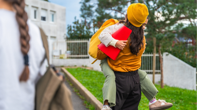 a picture of a mom hugging child after school, feeling lots of back-to-school emotions